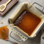 Overhead of glossy brown sugar syrup set in a lined pan, ready to pour